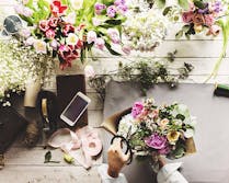 Various flowers, plants and accents atop a wooden workbench
